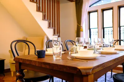 a wooden table with wine glasses and plates on it at Shibuya Urban Retreat - \u6771\u4eac\u89b3\u5149\u306b\u4fbf\u5229 - \u4ee3\u3005\u6728\u4e0a\u539f\u99c5\u304b\u3089\u5f92\u6b691\u5206 in Tokyo