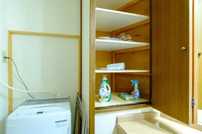 a cupboard with two bottles of detergent and a refrigerator at Shibuya Urban Retreat - \u6771\u4eac\u89b3\u5149\u306b\u4fbf\u5229 - \u4ee3\u3005\u6728\u4e0a\u539f\u99c5\u304b\u3089\u5f92\u6b691\u5206 in Tokyo