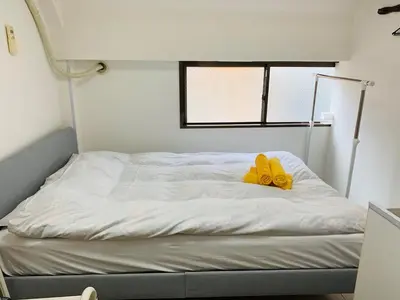 a bed with a pair of yellow shoes on it at Holiday Anytel Shinjuku#1 in Tokyo