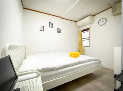 a bedroom with a bed with a yellow stuffed animal on it at Holiday Anytel Shinjuku#1 in Tokyo