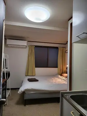 a bedroom with a bed with a light on the ceiling at Holiday Anytel Shinjuku#1 in Tokyo