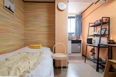 a bedroom with a bed and a clock on a wall at Holiday Anytel Shinjuku#1 in Tokyo