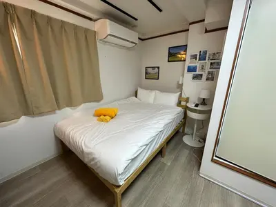 a small bedroom with a bed with a yellow stuffed animal on it at Holiday Anytel Shinjuku#1 in Tokyo