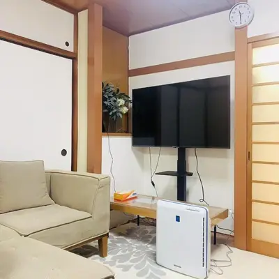 a living room with a couch and a flat screen tv at Japan House \u6e6f\u5cf6 in Tokyo