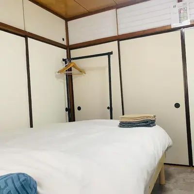 a bedroom with a white bed in a room at Japan House \u6e6f\u5cf6 in Tokyo