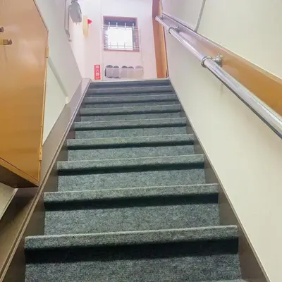 a stairway in a building with green stairs at Japan House \u6e6f\u5cf6 in Tokyo