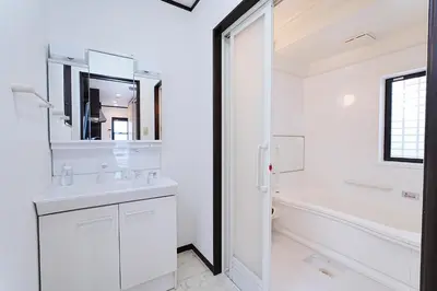 a white bathroom with a tub and a sink and a mirror at European villa in Tokyo