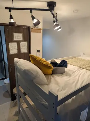 a hospital bed with a yellow pillow and some lights at Cozy stay with direct access to Narita & Haneda in Tokyo