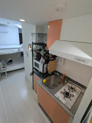 a small kitchen with a sink and a stove at Cozy stay with direct access to Narita & Haneda in Tokyo