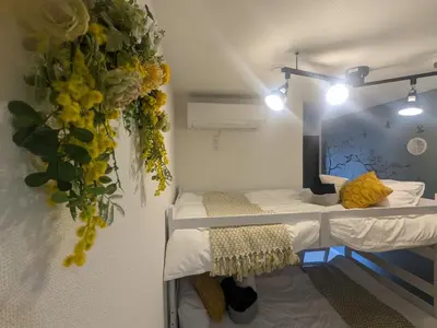 a room with two bunk beds and flowers on the wall at Cozy stay with direct access to Narita & Haneda in Tokyo
