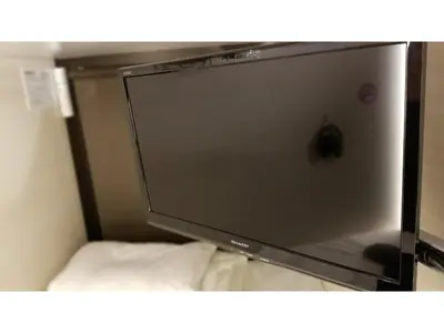 a large screen television sitting on top of a bed at GLANSIT AKIHABARA