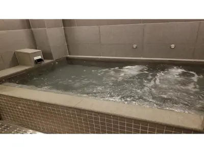 a bath tub filled with water in a bathroom at GLANSIT AKIHABARA