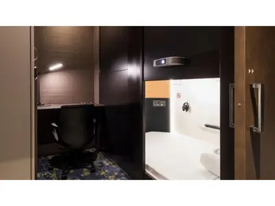a small room with a bed and a mirror at GLANSIT AKIHABARA