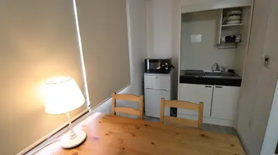 a small kitchen with a table and chairs and a lamp at Holiday Anytel Shinjuku#2 in Tokyo