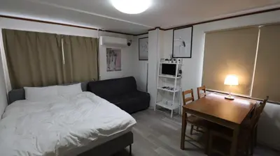 a bedroom with a bed and a table and a couch at Holiday Anytel Shinjuku#2 in Tokyo