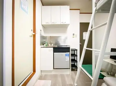 a small kitchen with a stove and a refrigerator at Holiday Anytel Shinjuku#2 in Tokyo