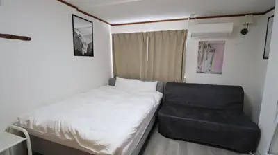 a small bedroom with a bed and a chair at Holiday Anytel Shinjuku#2 in Tokyo