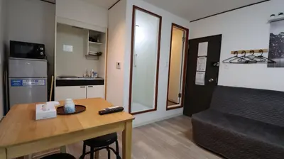 a small living room with a table and a kitchen at Holiday Anytel Shinjuku#2 in Tokyo