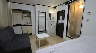 a room with a bed and a table and a kitchen at Holiday Anytel Shinjuku#2 in Tokyo