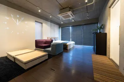 a living room with a couch and a clock on the wall at Grass BLDG 301 in Tokyo