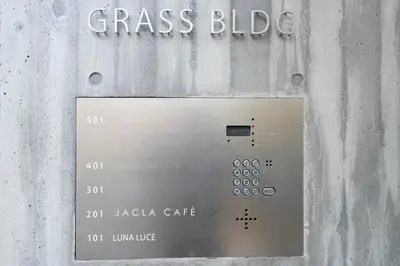 a metal door with a sign on the side of a building at Grass BLDG 301 in Tokyo