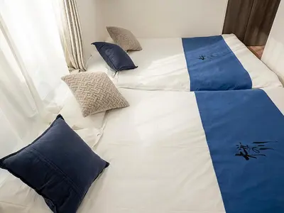a bed with blue and white sheets and pillows at \u685c\u306e\u5ddd64 \u6c60\u888b\u99c5C6\u53e3 8\u5206 2-11\u4eba\u4e28Ikebukuro JR Line C6 Exit 8 minutes 2-11 people in Tokyo