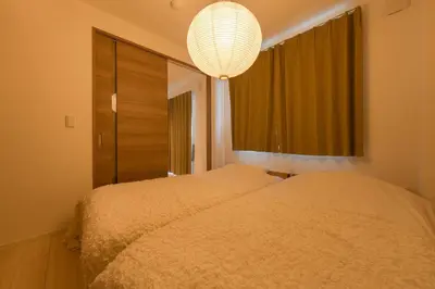 a bedroom with two beds and a chandelier at House hotel EKODA 301 HE31 in Tokyo