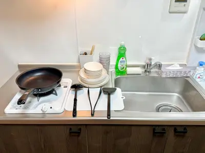 a kitchen counter with a sink and a pan on a stove at Shinjuku Waseda\u30cf\u30a6\u30b9 t2 in Tokyo