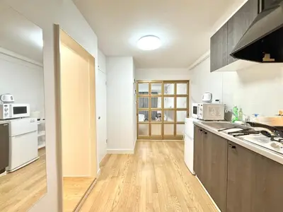 a kitchen with white appliances and a wooden floor at Shinjuku Waseda\u30cf\u30a6\u30b9 T3 in Tokyo