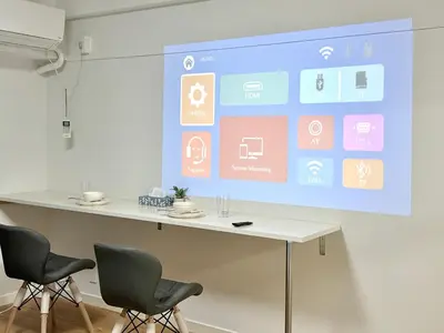 a presentation screen in a room with two chairs at Shinjuku Waseda\u30cf\u30a6\u30b9 T3 in Tokyo