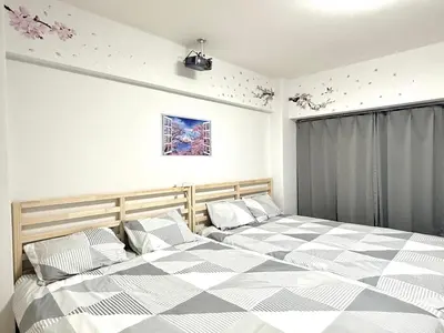 a bedroom with two beds and a window with flowers at Shinjuku Waseda\u30cf\u30a6\u30b9 T3 in Tokyo