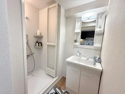 a white bathroom with a sink and a shower at Shinjuku Waseda\u30cf\u30a6\u30b9 T3 in Tokyo