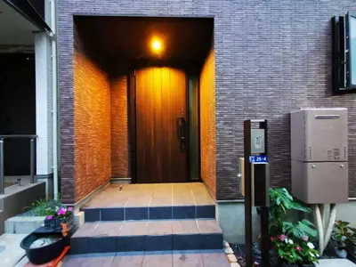 a building with a brown door and a brick wall at Newly Built 3-Story House in the Heart of Tokyo-Easy Access to Airports,Skytree in Tokyo