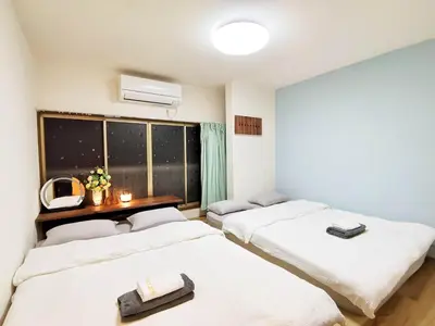 a room with three beds and a window at Asakusa Temple Detached BuildingZhujia Inn 2-8 people3 min walk to Asakusa Temple Skytree Ueno within walking distanceDirect access to Ginza, Shibuya, Shinjuku by subway in Tokyo