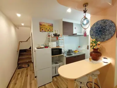 a small kitchen with a white refrigerator and a table at Asakusa Temple Detached BuildingZhujia Inn 2-8 people3 min walk to Asakusa Temple Skytree Ueno within walking distanceDirect access to Ginza, Shibuya, Shinjuku by subway in Tokyo