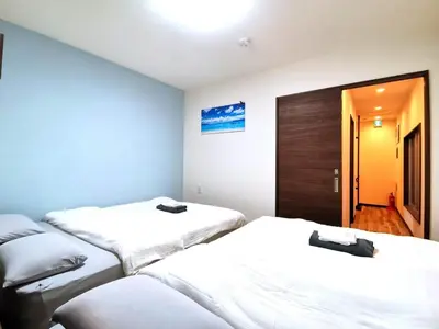 a room with three beds with white sheets at Asakusa Temple Detached BuildingZhujia Inn 2-8 people3 min walk to Asakusa Temple Skytree Ueno within walking distanceDirect access to Ginza, Shibuya, Shinjuku by subway in Tokyo