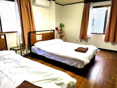 a bedroom with two beds and two windows at Holiday Anytel Shinjuku#3 in Tokyo