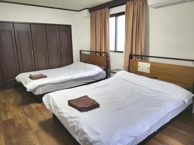 two beds in a hotel room with white sheets at Holiday Anytel Shinjuku#3 in Tokyo