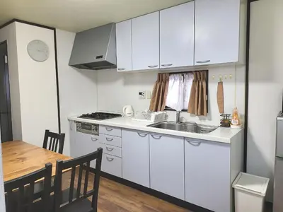 a kitchen with white cabinets and a table and a sink at Holiday Anytel Shinjuku#3 in Tokyo