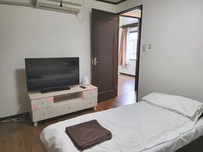 a bedroom with a bed and a flat screen tv at Holiday Anytel Shinjuku#3 in Tokyo