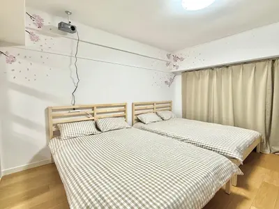 two twin beds in a room with a tv at Shinjuku Waseda\u30cf\u30a6\u30b9 T4 in Tokyo