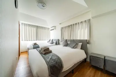 a bedroom with two beds and a large window at Kokoon Hotel Aoto in Tokyo