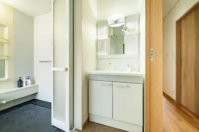 a white bathroom with a sink and a mirror at Kokoon Hotel Aoto in Tokyo