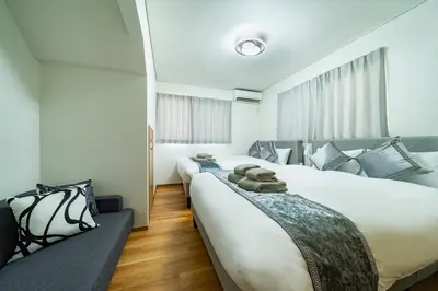 a bedroom with two large beds and a window at Kokoon Hotel Aoto in Tokyo