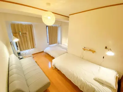 a living room with two beds and a couch at SATELLITE HOTEL Komagome \u30b5\u30c6\u30e9\u30a4\u30c8\u30db\u30c6\u30eb\u99d2\u8fbc in Tokyo