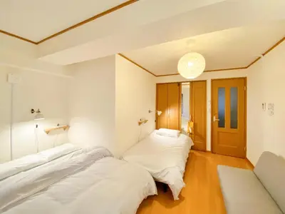 two beds in a room with white walls at SATELLITE HOTEL Komagome \u30b5\u30c6\u30e9\u30a4\u30c8\u30db\u30c6\u30eb\u99d2\u8fbc in Tokyo