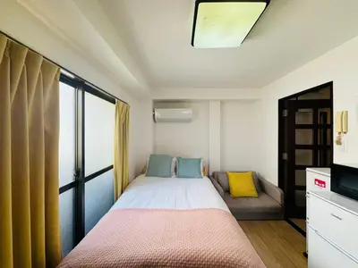 a small bedroom with a bed and a couch at Palasto Hostel-SJ0002 in Tokyo