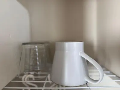 a white mug sitting on top of a kitchen counter at Palasto Hostel-SJ0002 in Tokyo