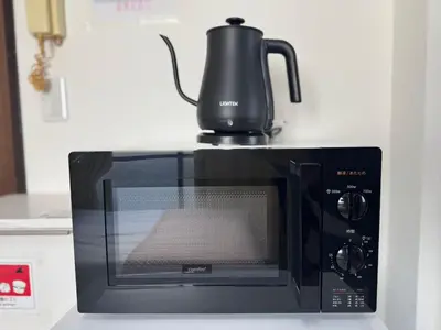 a black microwave with a kettle on top of it at Palasto Hostel-SJ0002 in Tokyo