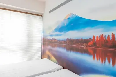 a bedroom with a mountain mural on the wall at FRt\u6075\u6bd4\u5bff2\u4e01\u76ee305 in Tokyo